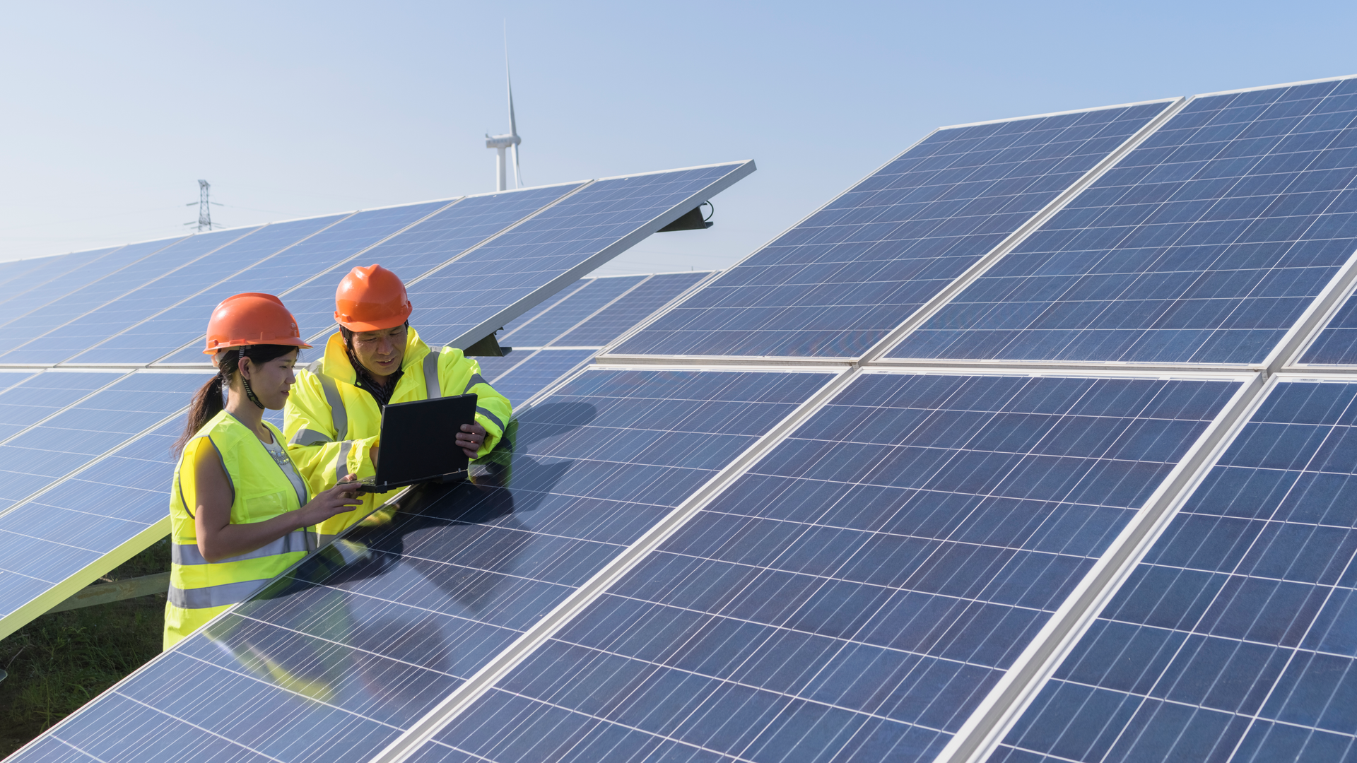 two construction workers by solar panels